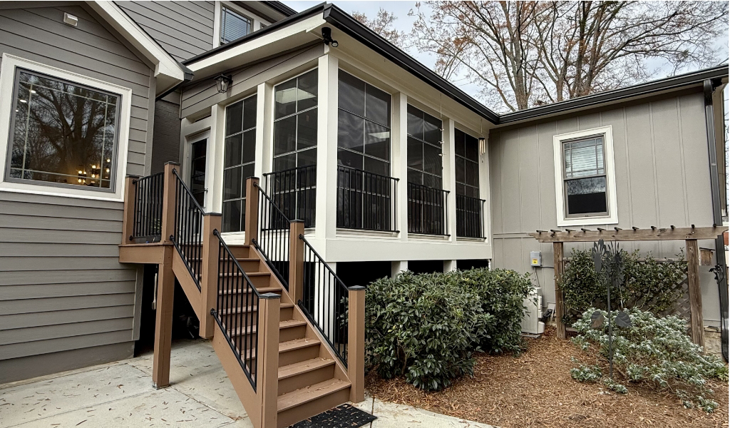 A two-story gray house with a glass-enclosed sunroom is complete with a professional painting project.