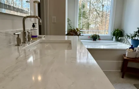 A modern bathroom with a marble countertop, faucet, and soap dispenser boasts serene elegance.