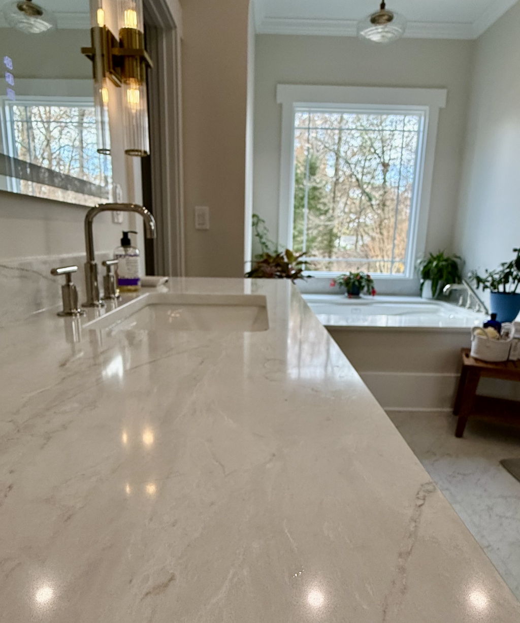 A modern bathroom with a marble countertop, faucet, and soap dispenser boasts serene elegance.